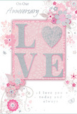 In this image, a softly romantic anniversary card lies open, its design blending pastel pinks and gentle silvery greys to create an intimate, cherished feel, as if it has been chosen from a boutique shop just off Lower Clapton Road. At the centre, the word "LOVE" appears in raised, glittered letters, the surface delicately textured so it appears both luminous and touchable. The letter "O" is transformed into a shimmering heart picked out in brighter silver, making it the emotional focal point and symbolising shared devotion. Surrounding this central word, clusters of delicate blossoms unfurl across the card in blush, mauve and pale cream, their edges rendered with a soft, almost watercolour effect. The flowers' flowing outlines and gentle colour transitions recall a romantic English spring garden, similar to the calm corners of nearby parks where blossom trees open in early April. Slender vines curl between the blooms, while tiny petals, playful swirls and subtle butterflies seem to drift in the background, adding light movement and whimsy. The typography is elegant yet understated: phrases such as "On Our Anniversary" and "I love you today and always" are written in a refined script that curves naturally with the floral forms. The overall composition is balanced and uncluttered, leaving enough open space for the design to breathe. It feels like a keepsake crafted for a couple marking their shared journey, gentle as a whisper yet deeply heartfelt, much like receiving a hand-delivered anniversary bouquet to a cosy flat near Clapton Pond, arranged with care by a florist who understands quiet, enduring romance.